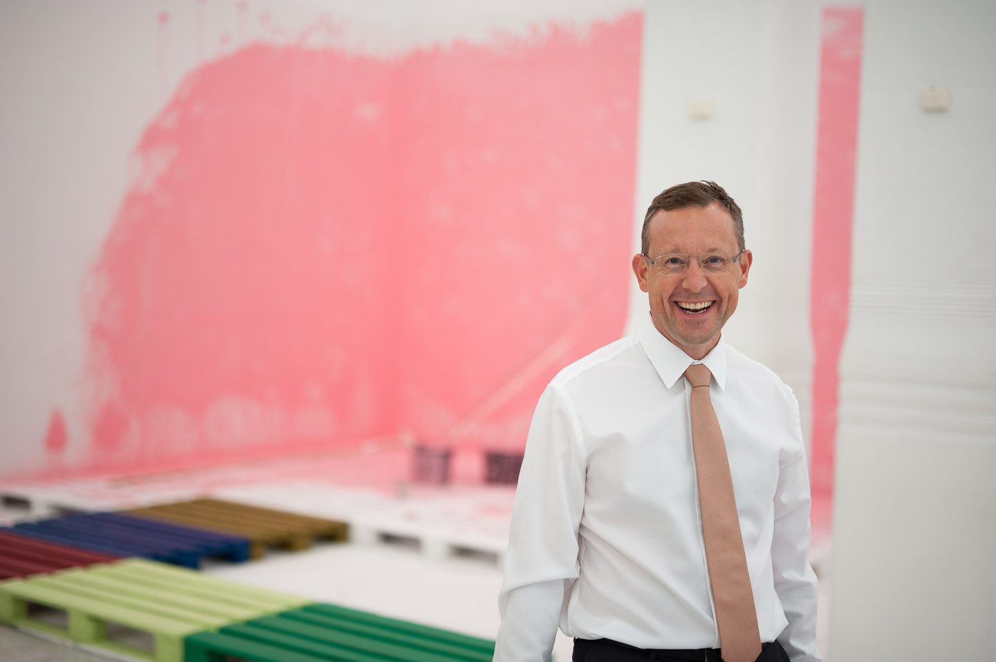 Tony Andersson, VD för Infrea, framför konstinstallationen Rosa Vägg samt EU pall och krita av Torbjörn Johansson.