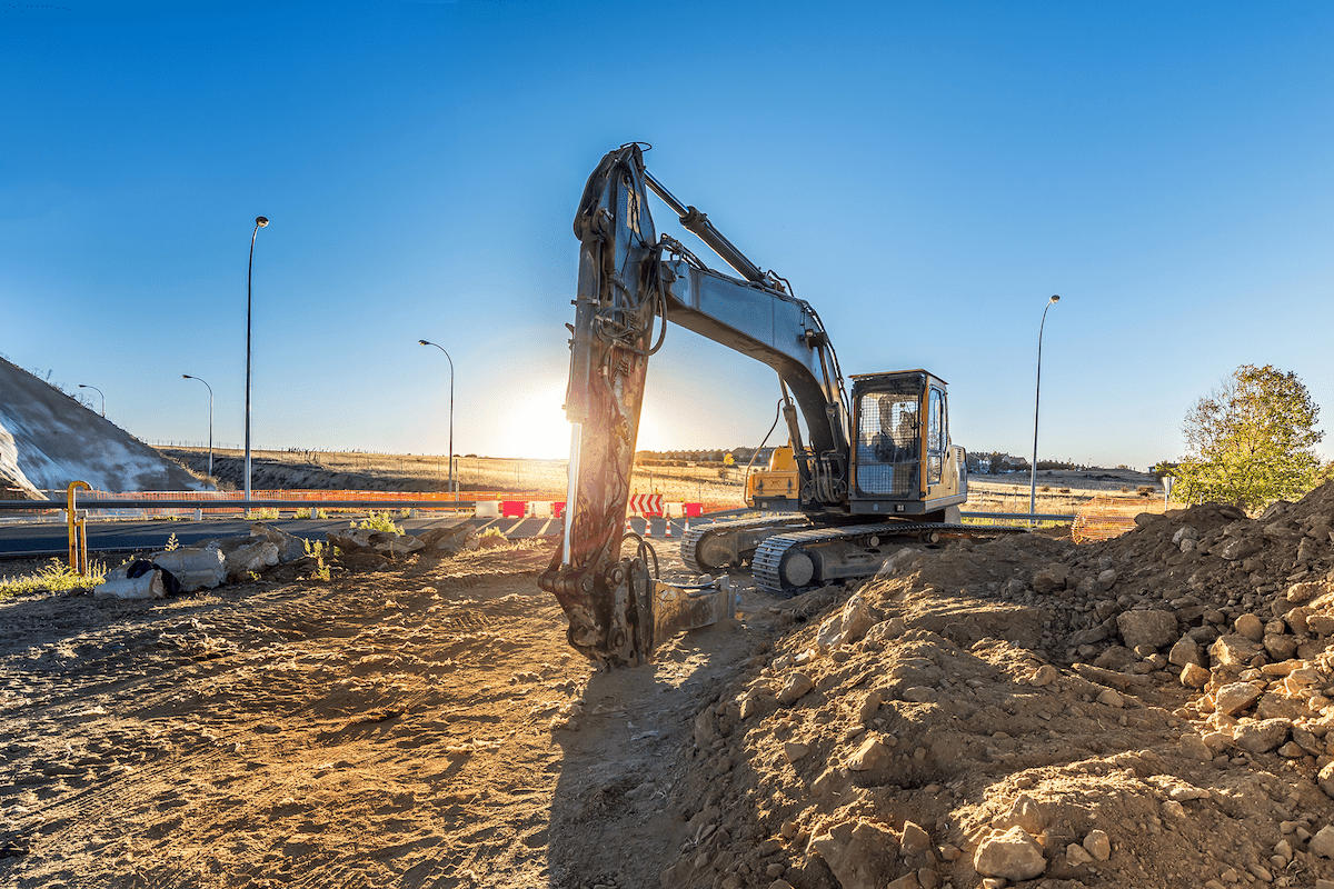 Grävskopa i solnedgång.